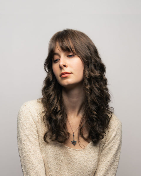 Woman with wispy bangs looking away from camera