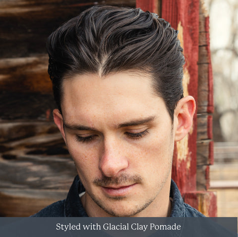 Close-up portrait of a young man with slicked-back dark hair. Styled with Glacial Clay Pomade.