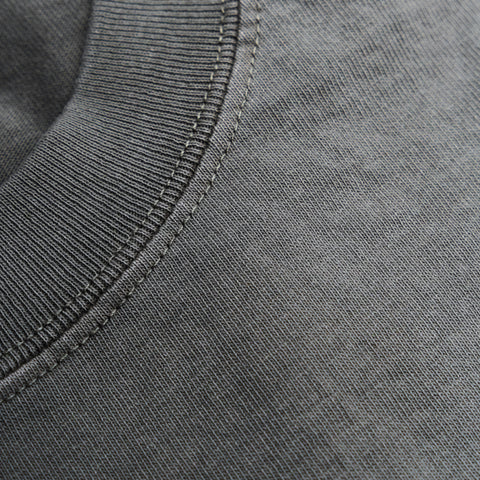 Gray tee close-up showing ribbed crew neckline, seam detail, and soft knit texture.