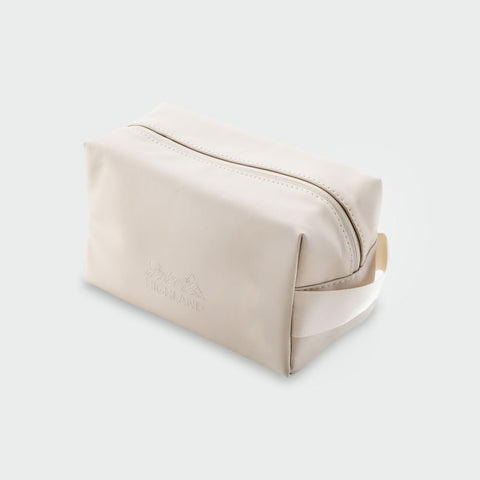 Angled view of Highland Dopp Kit showcasing its top zipper, side handle, and embossed logo on a light gray background