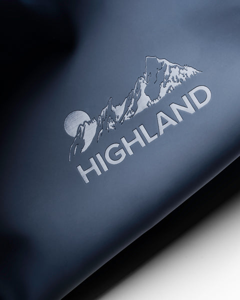 Close-up of the Highland Dopp Kit in Slate showcasing the Highland logo on its smooth water-resistant material