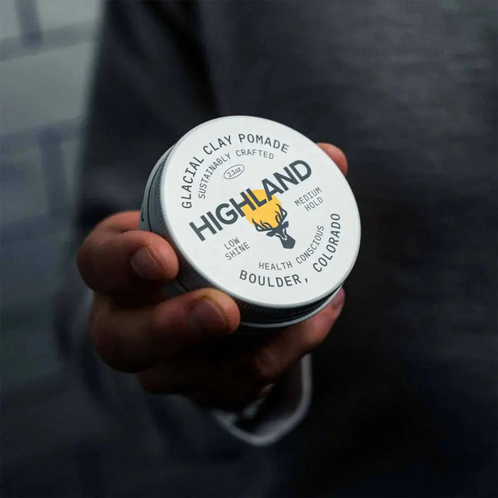 HIGHLAND GLACIAL CLAY POMADE SUSTAINABLY CRAFTED 2.1oz LOW SHINE MEDIUM HOLD HEALTH CONSCIOUS BOULDER COLORADO hand holding