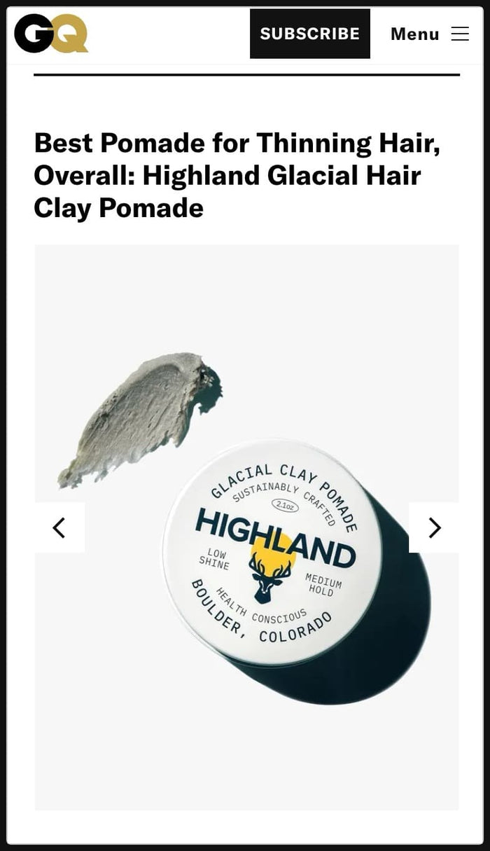 Angled top view of Highland Glacial Clay Pomade tin showing lid label and a smear of gray pomade on a white background