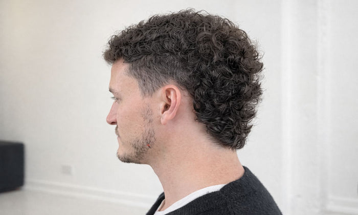Side profile of a man with a curly mullet