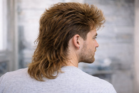 man looking to the side with a mullet