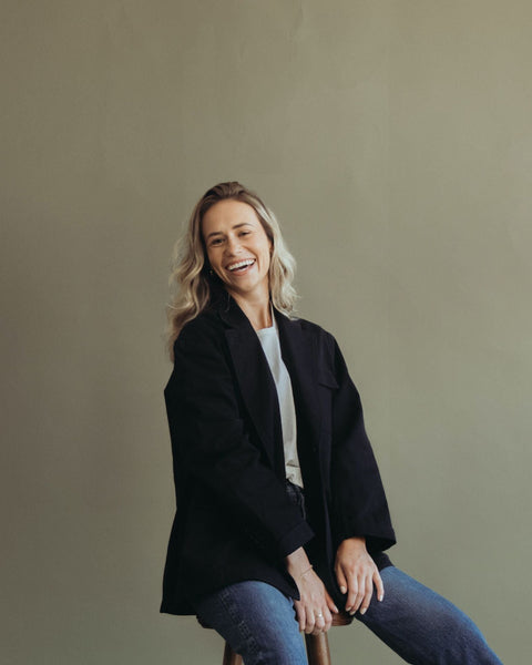 woman with blonde wavy hair sitting on stool