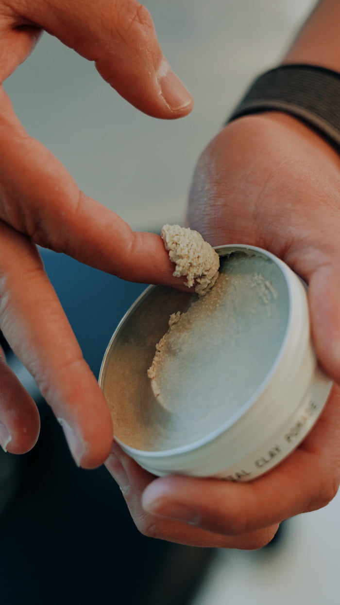 Tub of Highland Clay pomade being used