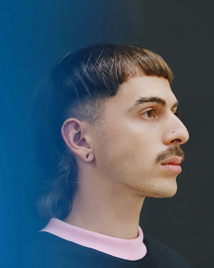Man with an earring and a taper mullet haircut