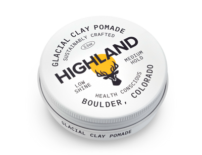 Tin labeled HIGHLAND GLACIAL CLAY POMADE SUSTAINABLY CRAFTED 2.1oz LOW SHINE MEDIUM HOLD HEALTH CONSCIOUS BOULDER, COLORADO