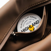Close-up of the Highland Dopp Kit showcasing its open interior with Highland Glacial Clay Pomade inside