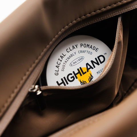Close-up of the Highland Dopp Kit showcasing its open interior with Highland Glacial Clay Pomade inside
