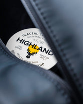 Close-up of the Highland Dopp Kit showcasing a Glacial Clay Pomade jar inside its dark water-resistant compartment
