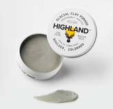 Open tin of glacial clay with smear, lid label reads 'HIGHLAND', 'GLACIAL CLAY POWDER', 'ESTES, COLORADO'