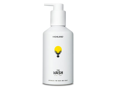 White pump bottle labeled HIGHLAND with deer logo and yellow sun; product name 'THE WASH' and small text 'OPTIMIZED FOR HAIR AND SCALP'.